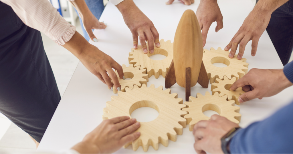 Hands on a Desk holding wheels, collaborating together